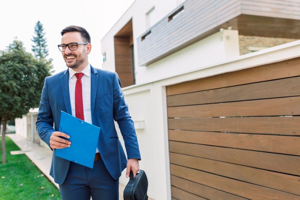 man with folder next to house